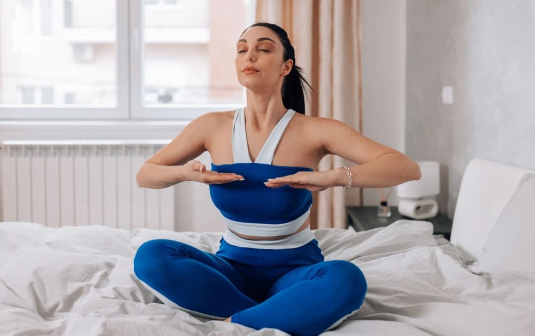 front view of a lady doing meditation on bed in the morning after wakeup