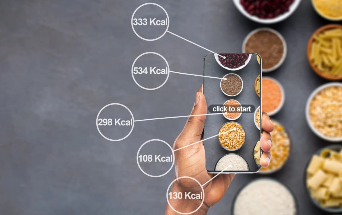 A hand holding a smartphone scanning food items, with calorie information displayed for various grains.
