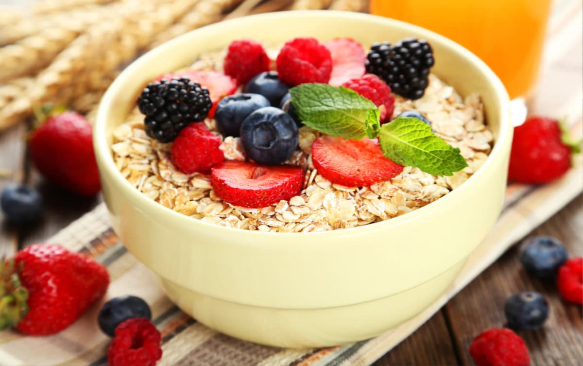 Bowl of rolled oats topped with fresh berries and mint leaves